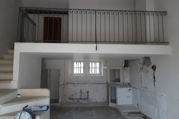 Interior de una masía antes de la reforma con paredes deterioradas e instalaciones vistas