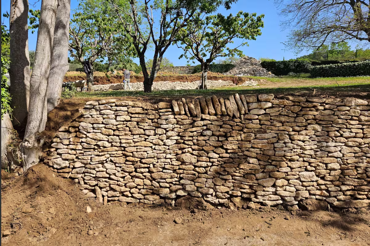 Muro de piedra construido en el acceso a una masía